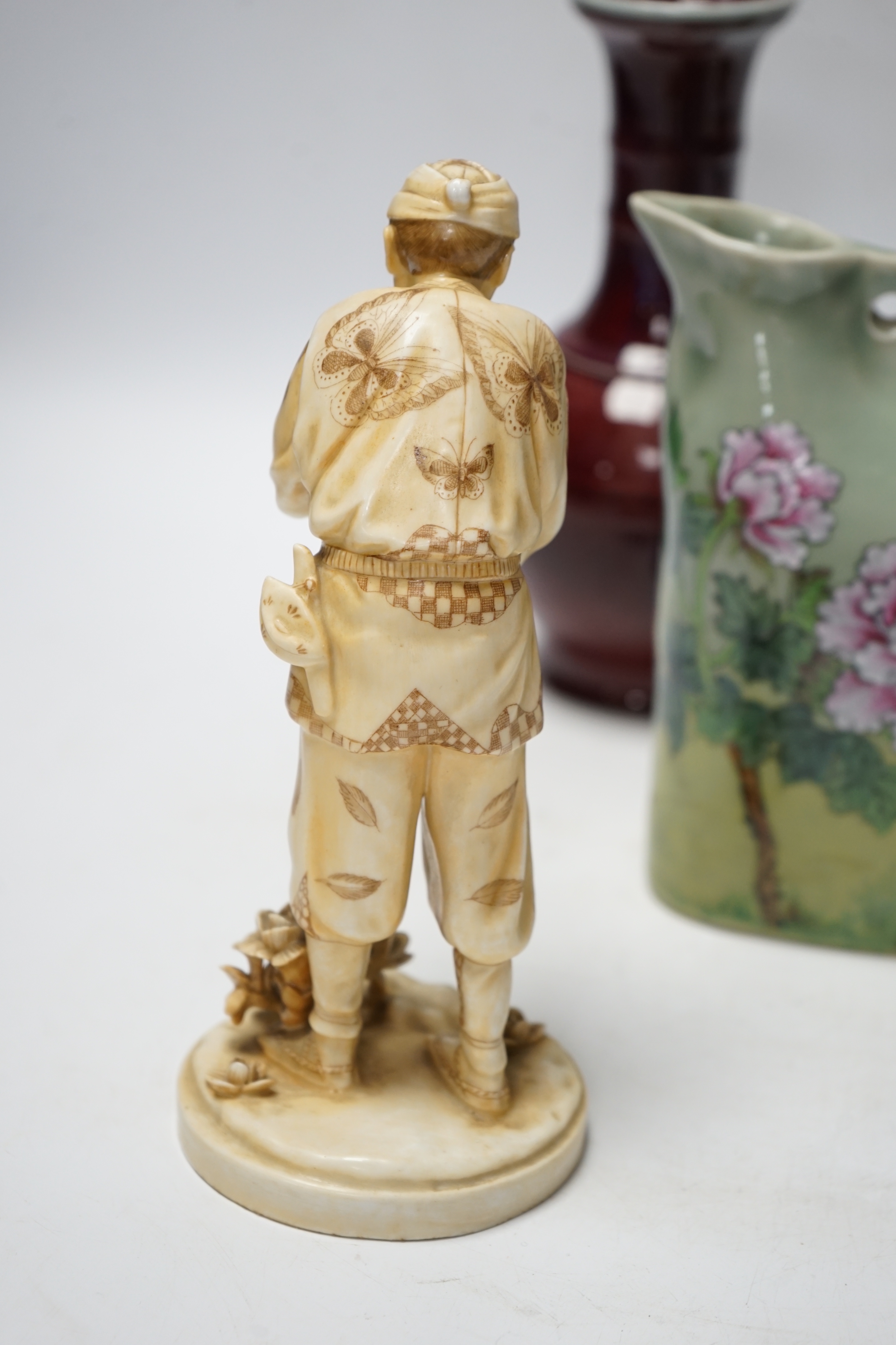 A Chinese flambé vase, famille rose jug, celadon plant pot and a Japanese porcelain figure, tallest 23cm